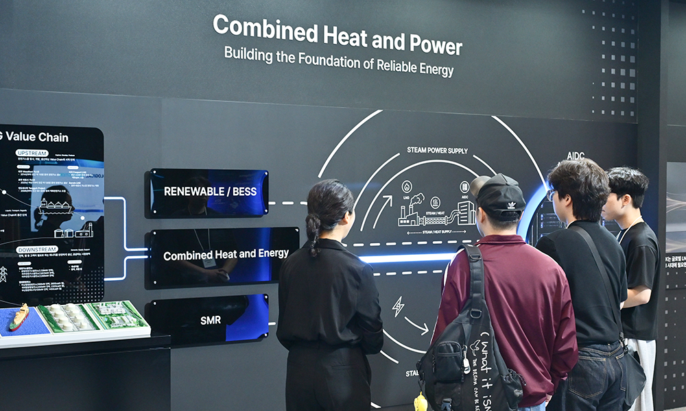 '2026 기후산업국제박람회(WCE)' SK 전시관에서 관람객들이 열병합발전(Combined Heat and Power) 존을 살펴보고 있다. 재생에너지·BESS·SMR이 결합된 발전 구조도가 표시되어 있다