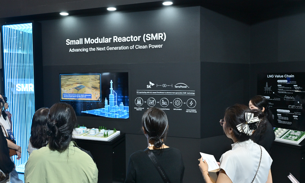 'WCE 2026' SK 전시관 SMR(Small Modular Reactor) 존을 살펴보는 관람객들. 나트륨 SMR 원자로 구조물 그래픽이 표시되어 있다